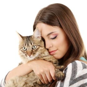 Beautiful young woman cuddling a cat isolated on a white background.