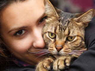 cropped-woman-cuddles-tabby-cat-1.jpg