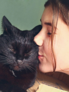 woman kisses black cat why does my cat lie on my chest